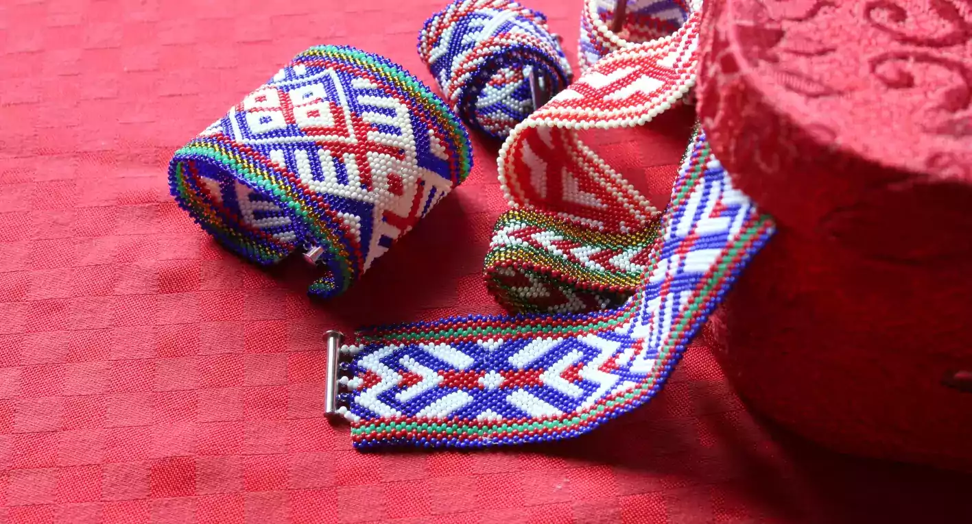 Karoliukų apyrankės šalia raudonos dežutės