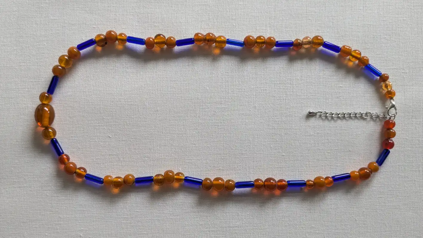 Stiklo karolių verinys ant lygaus paviršiaus.